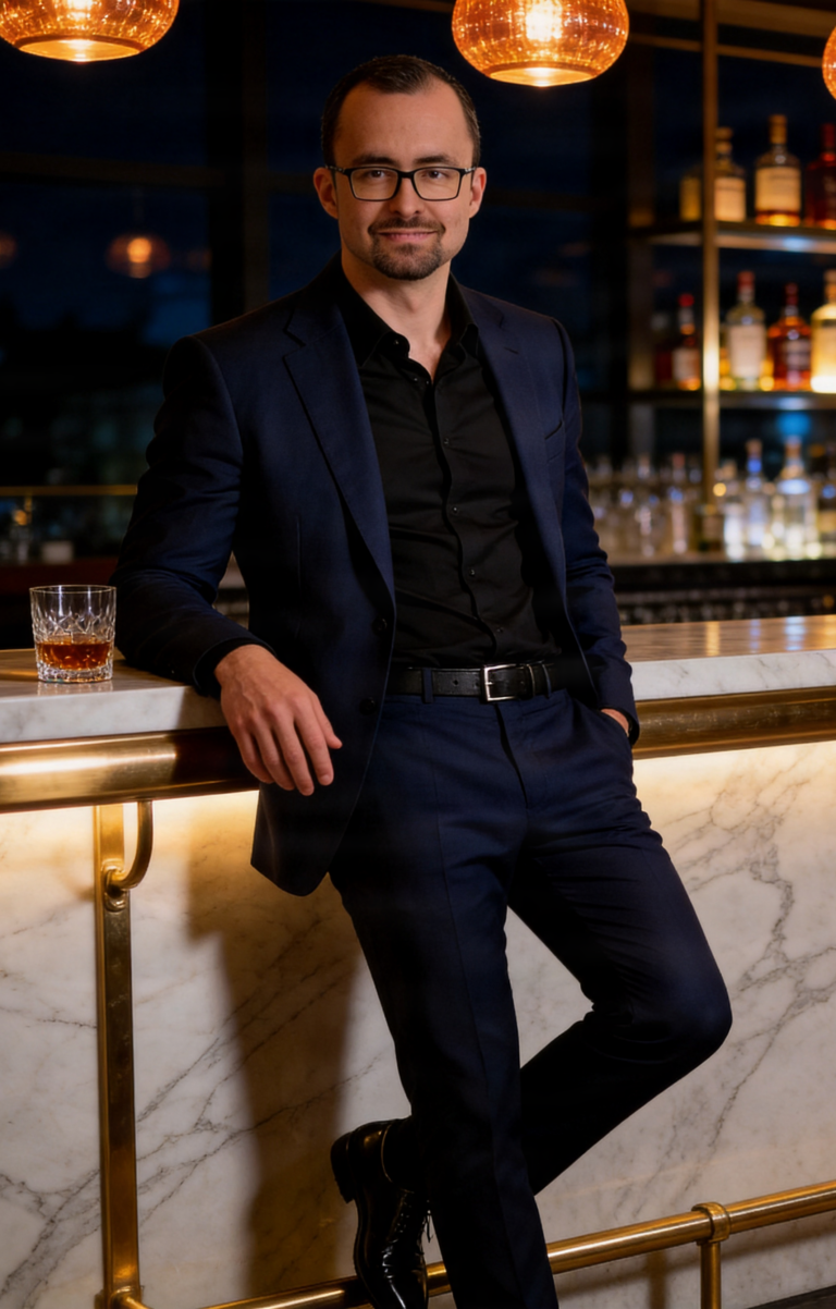 Ganzkörperporträt von Callboy Alexander im blauen Anzug, stehend an einer Cocktailbar.