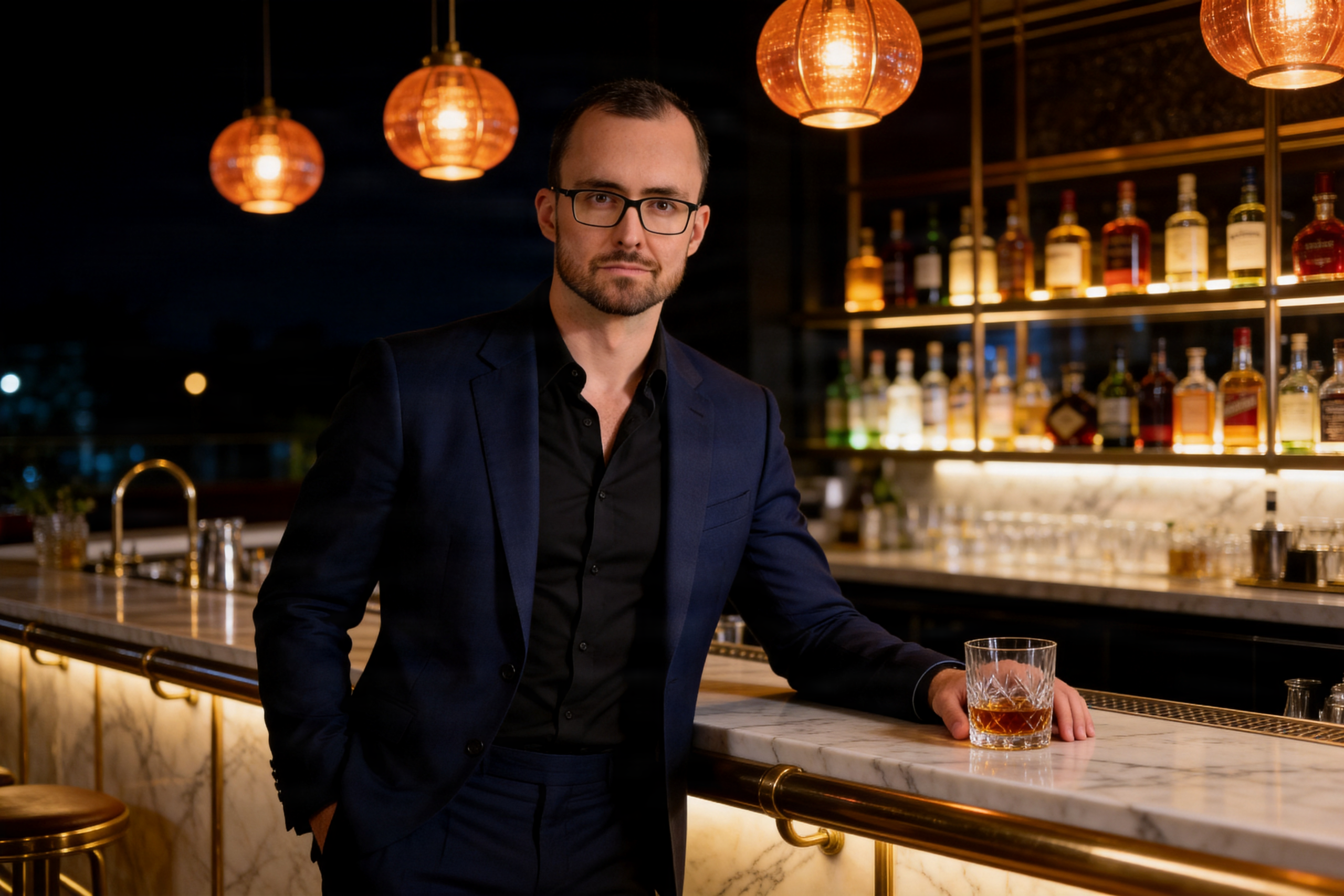 Escort_Mann_Alexander_stehend_an_Cocktailbar_Hand_am_Glas_blauer_Anzug